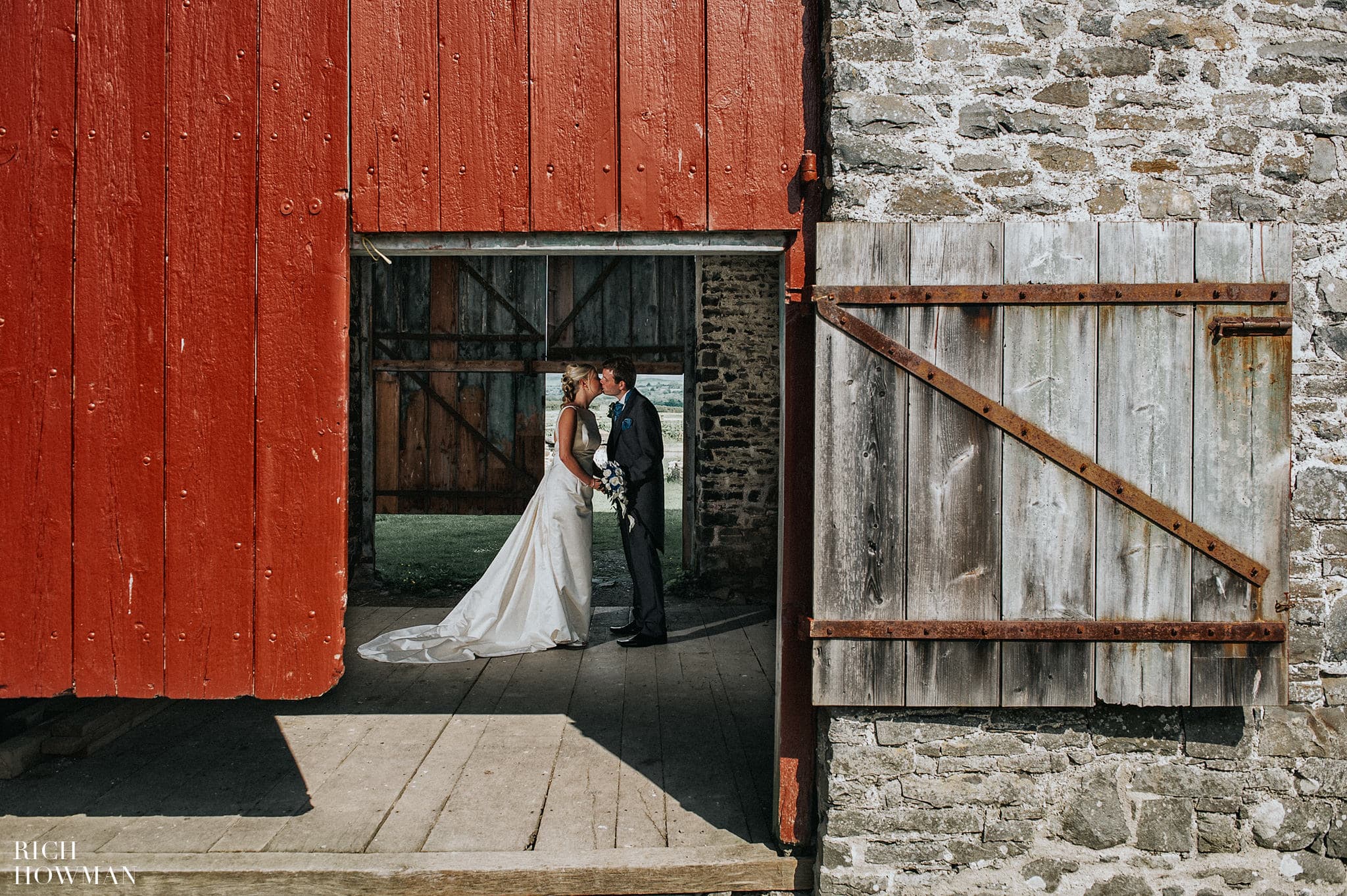 Llanerchaeron wedding. The bride and groom photographed in the barn by Rich Howman wedding photographer