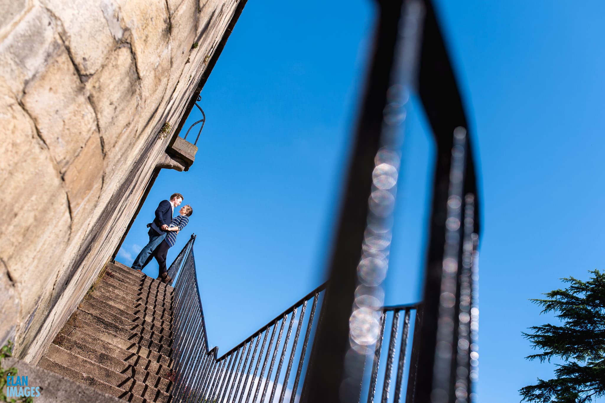 Bristol Engagement Photographer - couple kissing with a deep blue sky in Clifton Village