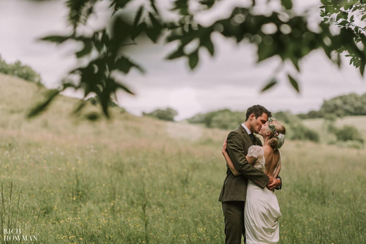 bride and groom overlooking fields for a kiss after their folly farm centre wedding
