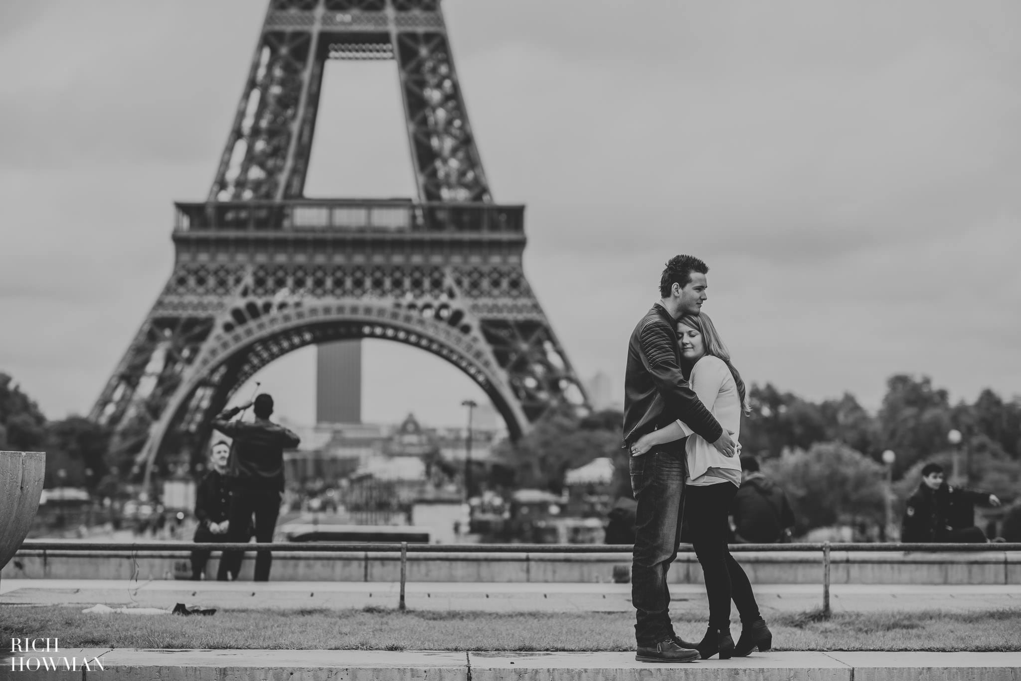 Black and white photo of a couple hugging at the eiffel tower