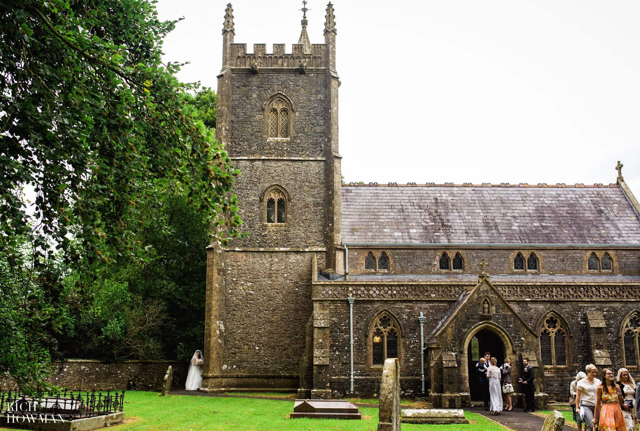 The married couple hide around the corner of the St. James' Church Ashwick to allow their wedding guests to leave and form a confetti line