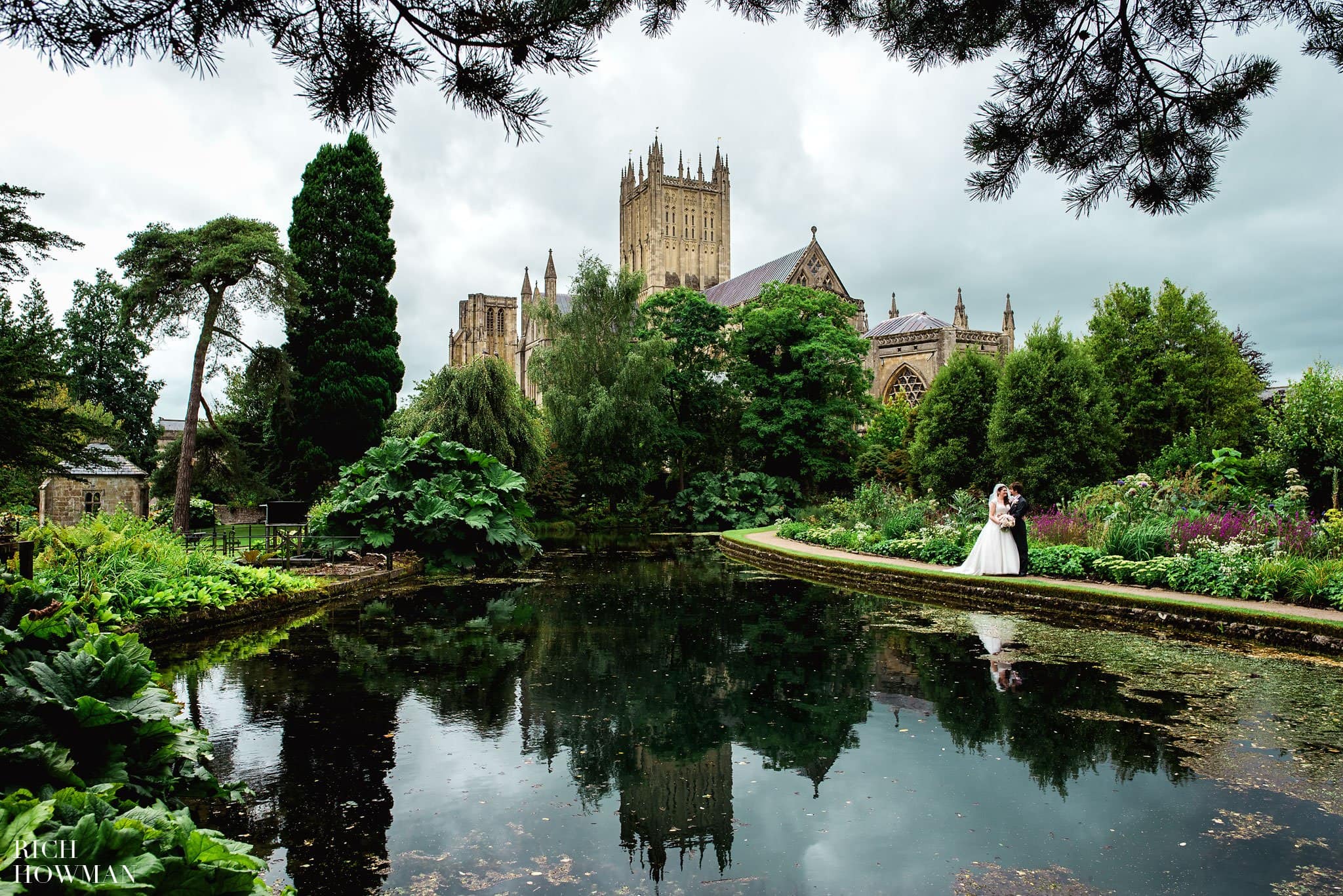 Wedding Photographer at the Bishops Palace photographing the bride and groom with Wells cathedral in the background