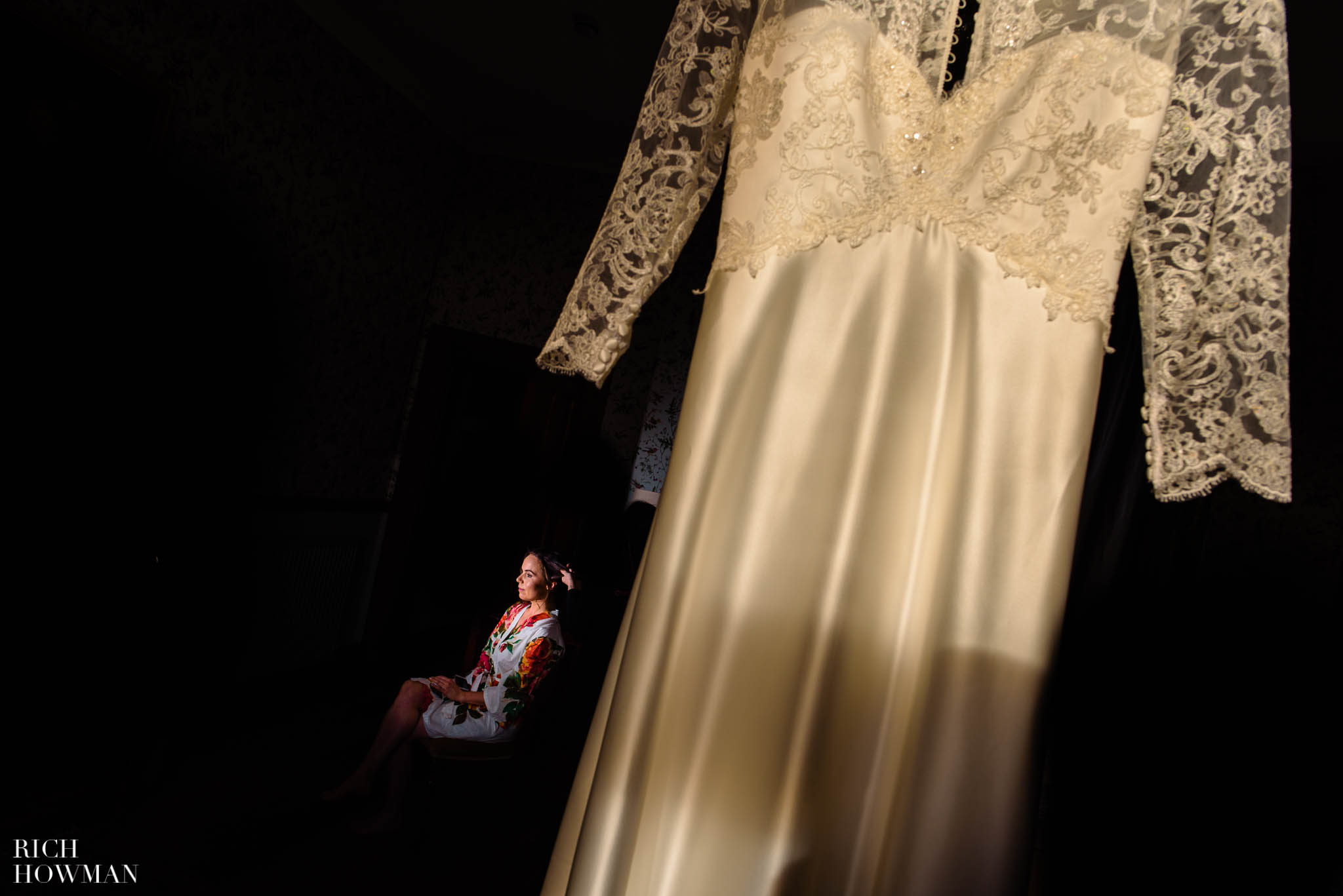 wedding dress in window light with bridal prep in the background, captured by Huntsham court wedding photographer, Rich Howman