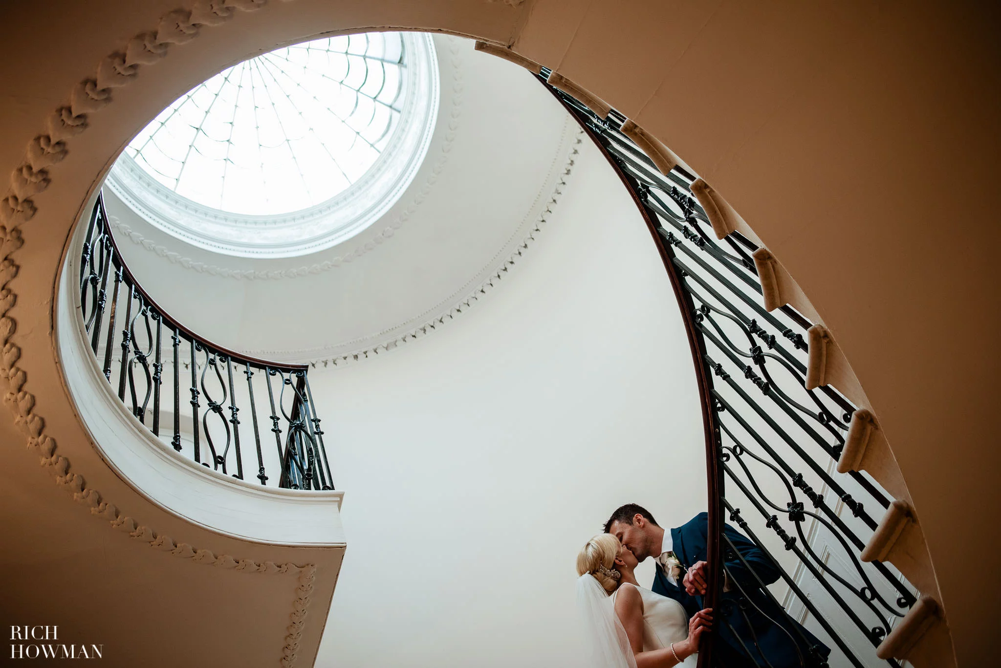 bride and groom on spiral staircase by eastington park wedding photographer, rich howman