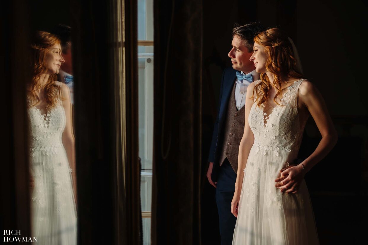 bride and groom in window light captured by devon wedding photographer, rich howman