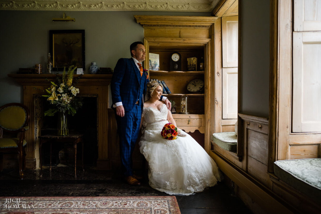 bride and groom in window lit portrait captured by moonraker hotel wedding photographer, rich howman