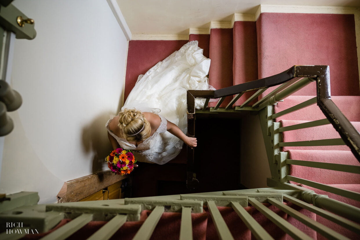 bride on stairs in window light, cpatured by moonraker hotel wedding photographer, rich howman