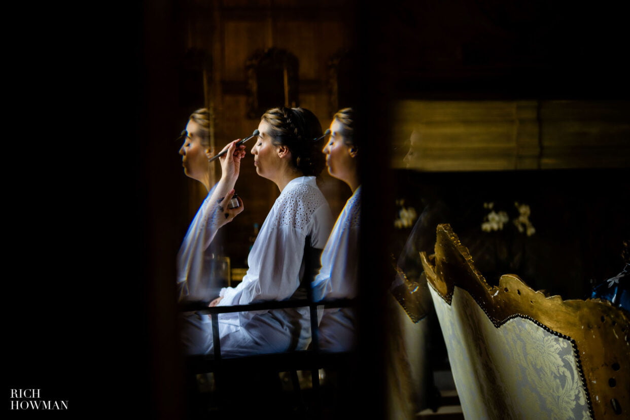 bridal make up preparation in reflection, captured by Hengrave Hall wedding photographer, rich howman