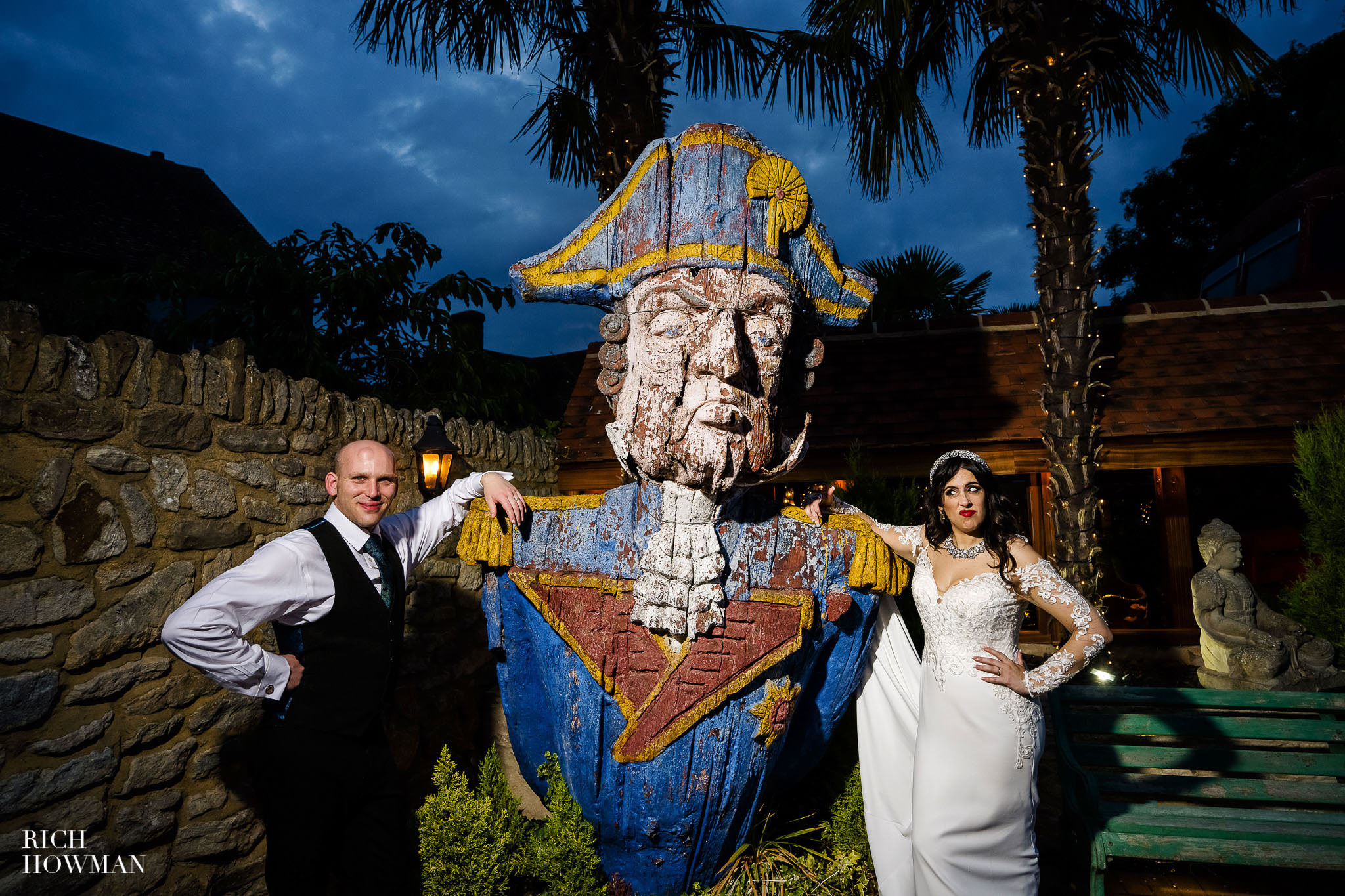 Bride and groom portrait with giant wooden ships-head, captured by by crazy bear wedding photographer, rich howman