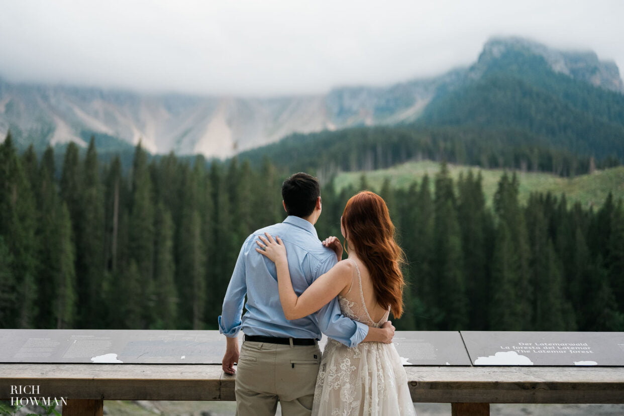 bride and groom look out over lake, captured by dolomites wedding photographer, Rich Howman