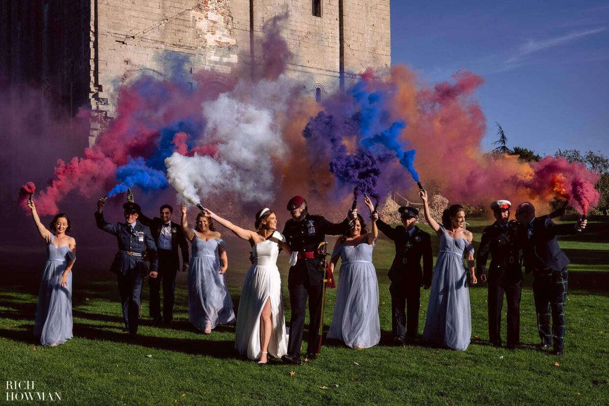 wedding party with smoke flares, captured by hedingham castle wedding photographer, rich howman