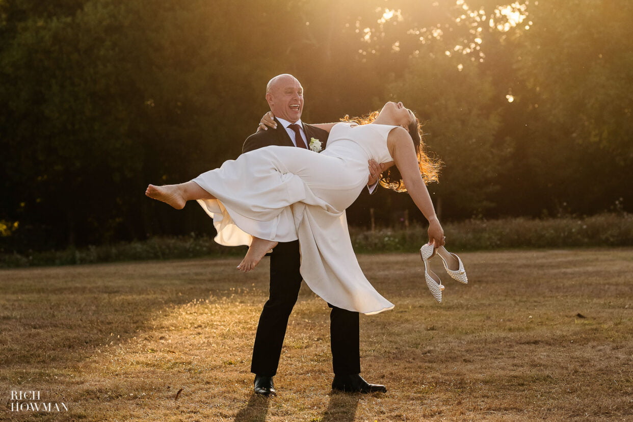 groom spinning his bride on the lawn at golden hour, captured by Clevedon Hall wedding photographer, Rich Howman