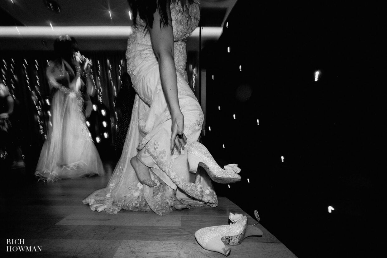 bride kicks off her shoes at a Moddershall Oaks wedding, captured by Rich Howman
