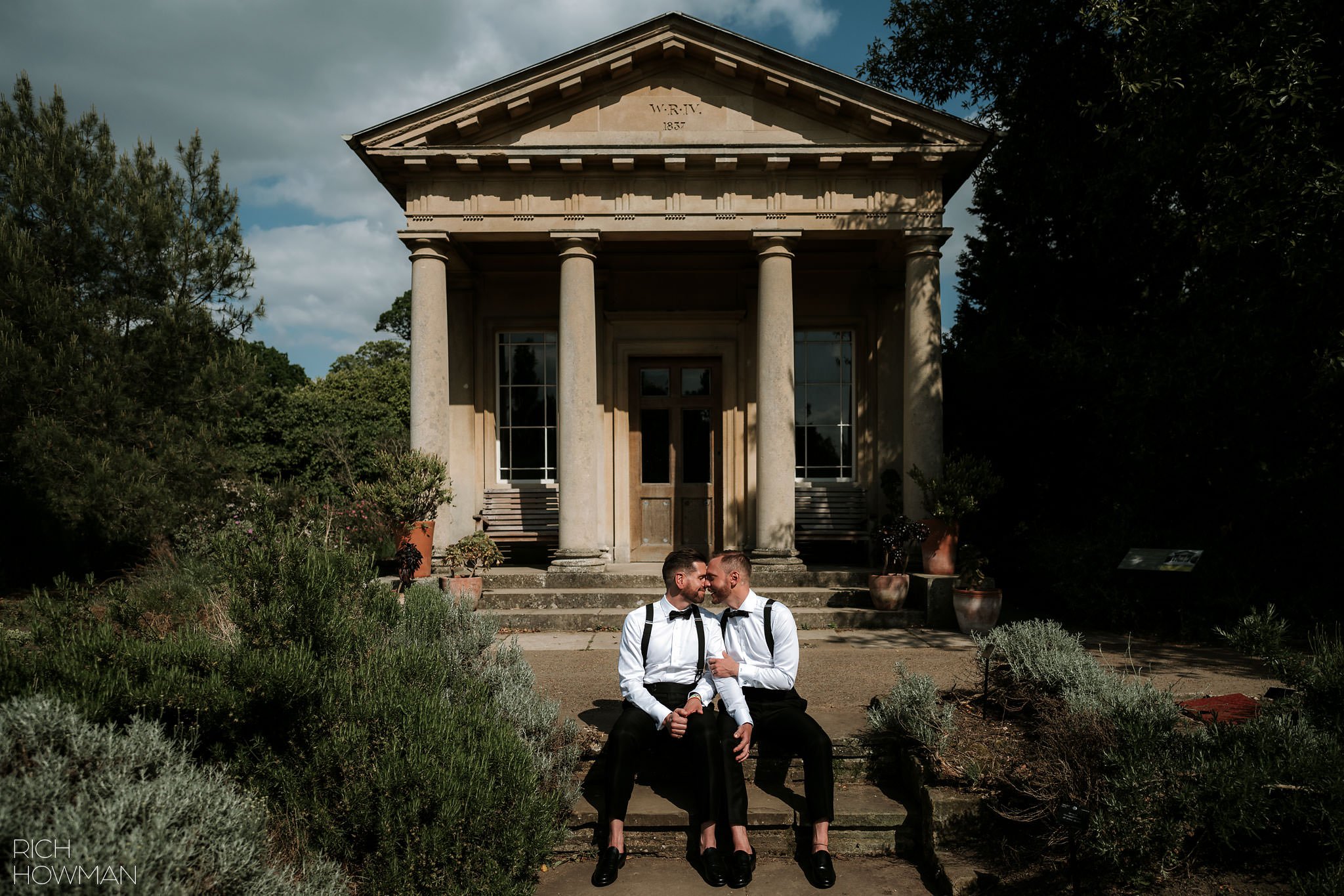newly married couple sitting on the steps of king william's temple at Kew Gardens after their ceremony captured by cambridge cottage wedding photographer, Rich Howman