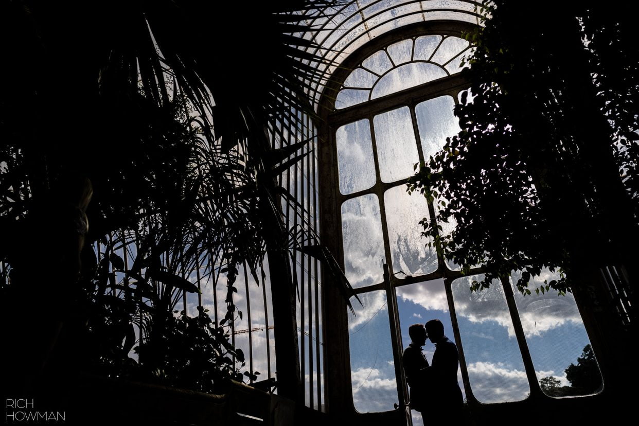 glass house silhouette of two grooms captured by Cambridge Cottage wedding photographer, Rich Howman