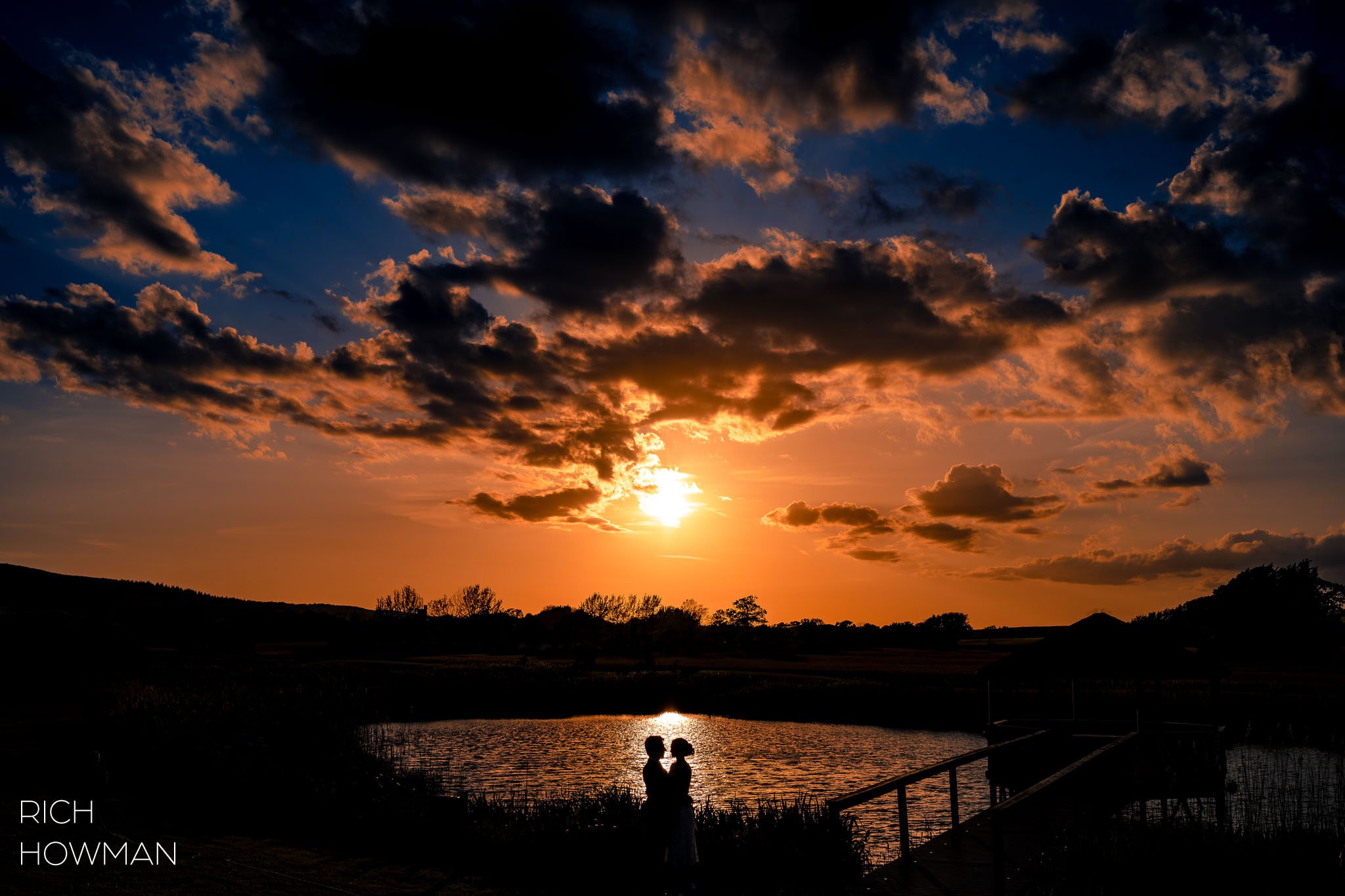 bride and groom on the jetty at sunset, captured by Quantock Lakes wedding photographer, Rich Howman