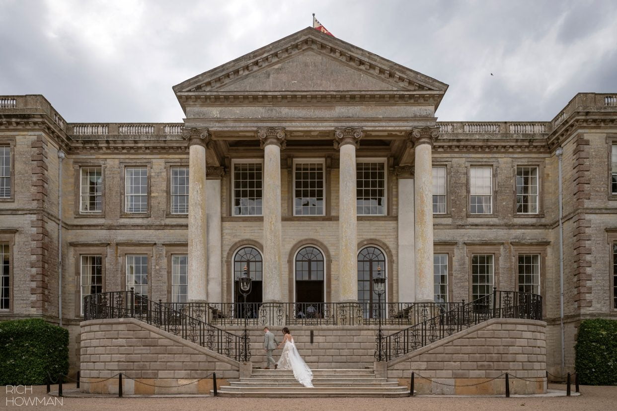 bride and groom on the impressive stairs outside Ragley Hall, captured by Ragley Hall wedding photographer, Rich Howman