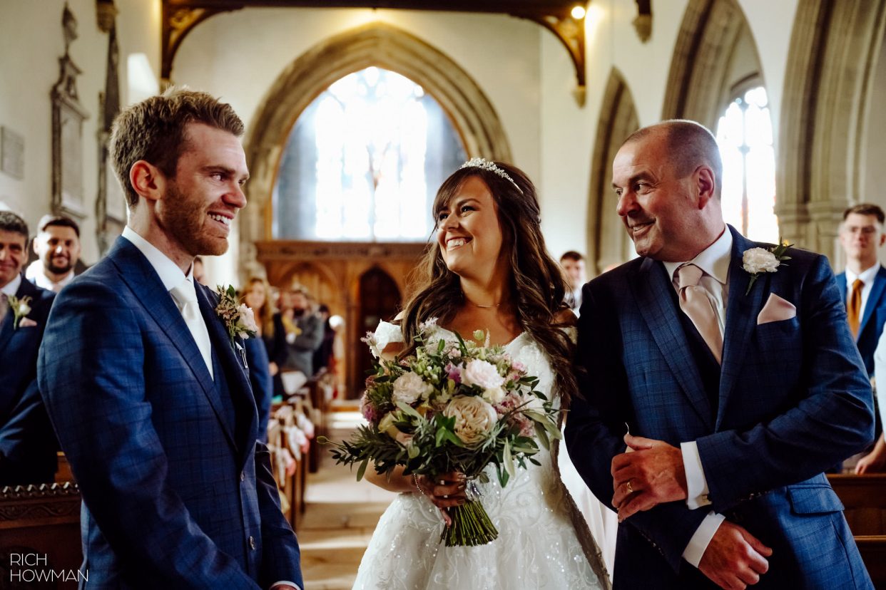 bride and groom meet at the top of the church aisle, captured by tetbury wedding photographer, Rich Howman