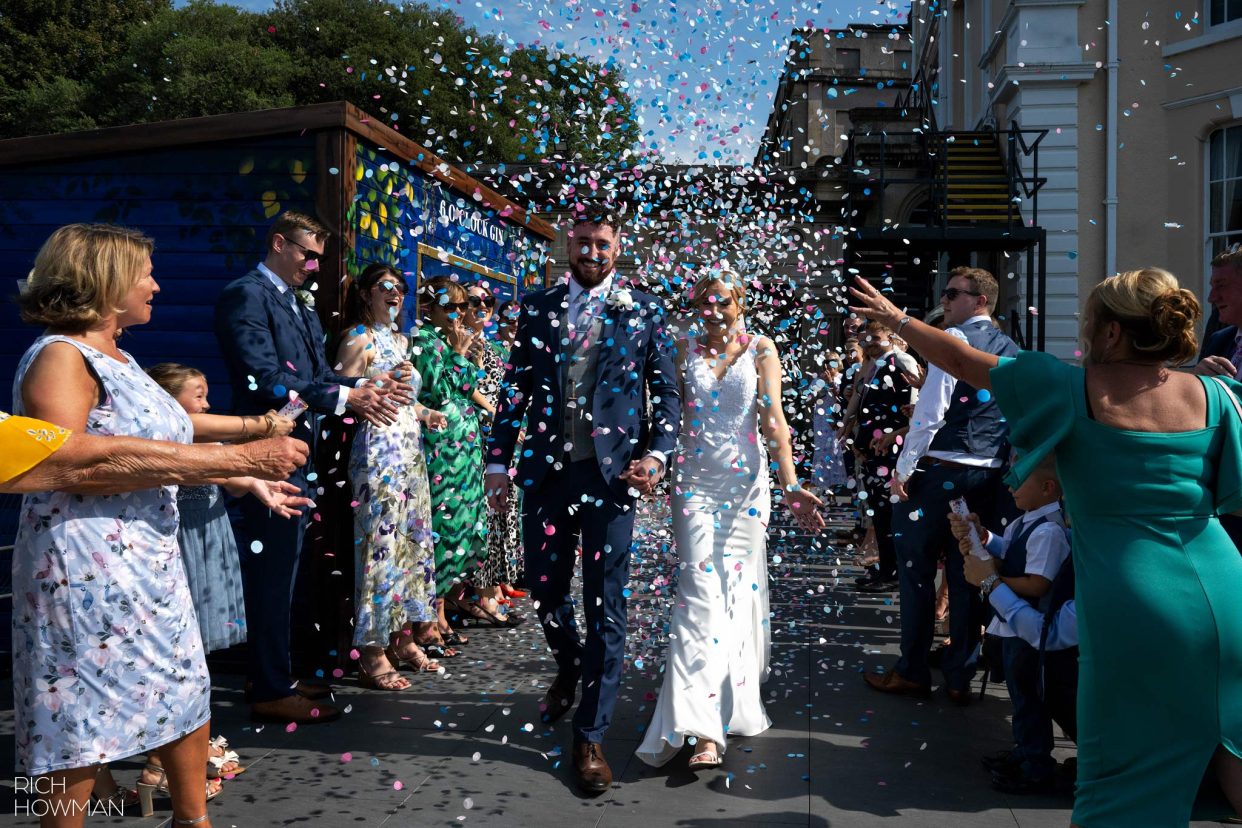 bride and groom showered with confetti, captured by hotel du vin Bristol wedding photographer, Rich Howman