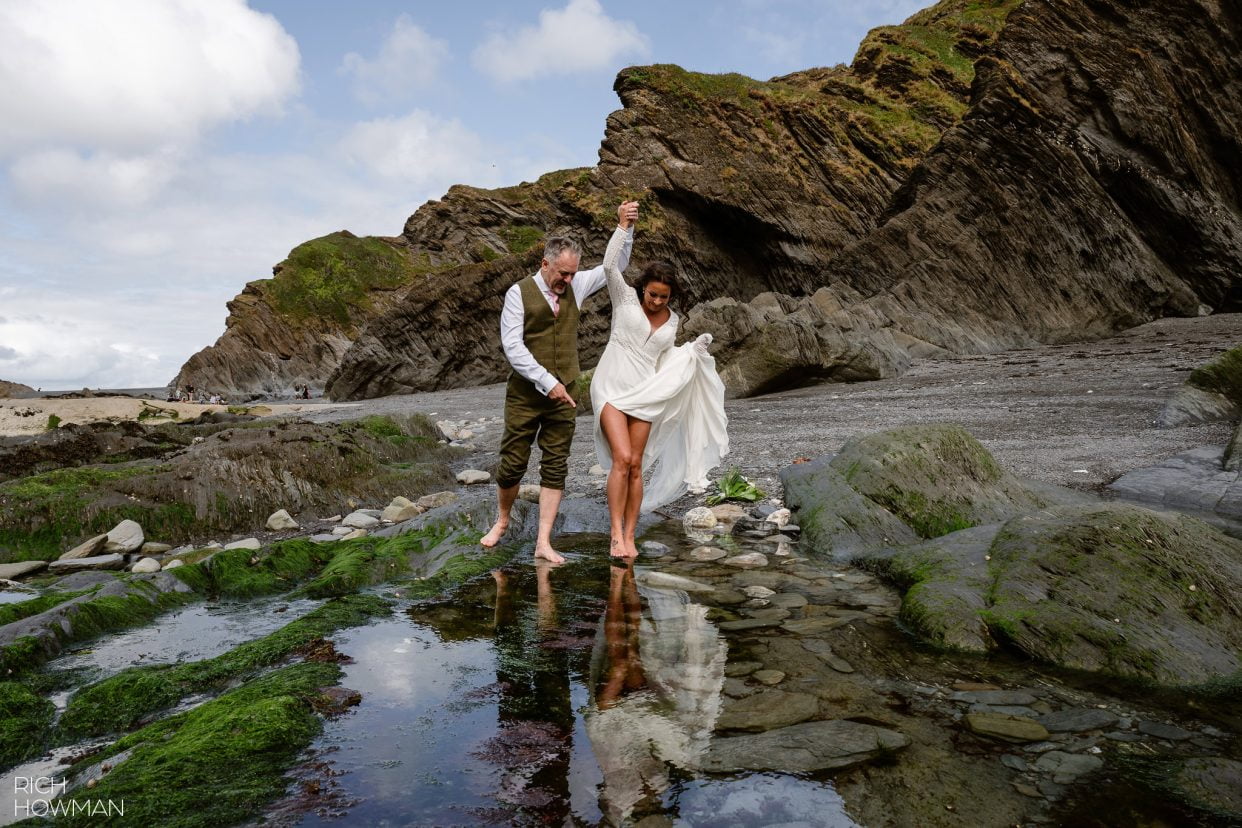 bride and groom paddling at the beach, captured by North Devon wedding photographer, Rich Howman