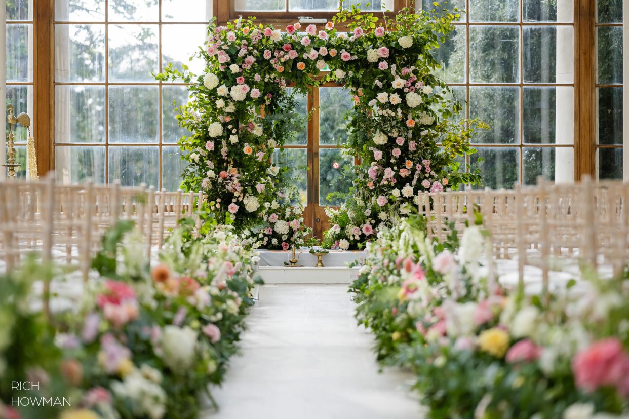 Stunning floral arch and aisle displays captured by Nash Conservatory wedding photographer, Rich Howman